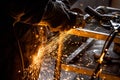 Close up of car mechanic hands welding grinding machine.Sparks of grinding machine while cutting car exhaust pipe