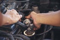 Close up Car Mechanic man hands repairing car auto repair shop. Man hands fixing machinery vehicle mechanical service. open Royalty Free Stock Photo