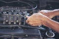 Close up Car Mechanic man hands repairing car auto repair shop. Man hands fixing machinery vehicle mechanical service. open Royalty Free Stock Photo