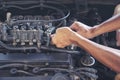 Close up Car Mechanic man hands repairing car auto repair shop. Man hands fixing machinery vehicle mechanical service. open Royalty Free Stock Photo