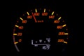 Close up of car speedometer with the needle pointing at 90 kmh on black blackground