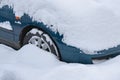 Close up on car standing in the parking lot covered with a thick layer of snow.