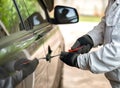 Close up car thief holding screwdriver trying door handle Royalty Free Stock Photo