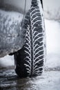 Car tire in winter on the road covered with snow, close up picture