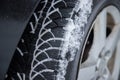 Car tire in winter on the road covered with snow, close up picture