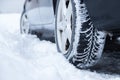 Car tire in winter on the road covered with snow, close up picture