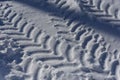 Close up car tire tracks in the white snow. Low sun, blue shadows. Top view. Winter roads. Passability of the car. Royalty Free Stock Photo