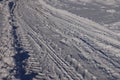 Close up car tire tracks in the white snow. Low sun, blue shadows. Top view. Winter roads. Passability of the car. Royalty Free Stock Photo