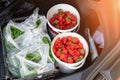 Close-up car trunk with fresh ripe organic vegetables and berries bought on farmers market. Red juicy sweet strawberries ,