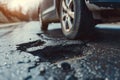 Close up of a car tyre next to a pothole in the road Royalty Free Stock Photo