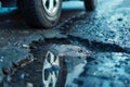 Close up of a car tyre next to a pothole in the road Royalty Free Stock Photo