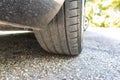 Close up of car tyre tread on the asphalt road on a bright day.