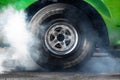 Close up car wheel with smoke on the asphalt road speed track, Car wheel drifting and smoking on track, Car wheel spinning Royalty Free Stock Photo