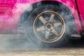 Close up car wheel with smoke on the asphalt road speed track, Car wheel drifting and smoking on track, Car wheel spinning Royalty Free Stock Photo