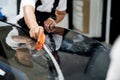 Close-up of car wrapping specialist hand straightening wrapping transparent film for protection with a film cutter to cut a film. Royalty Free Stock Photo