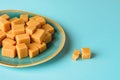 Close-up of caramel vanilla fudge on a turquoise ceramic plate over turquoise background. Fresh tasty candies made of milk and Royalty Free Stock Photo