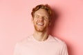 Close up of carefree man with red hair and beard, laughing and feeling happy, standing over pink background, having fun Royalty Free Stock Photo