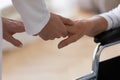 Close up caregiver holding disabled older woman hand