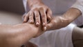 Close up caregiver holding older patient hands, showing support