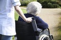 Close Up Of Carer Pushing Senior Woman In Wheelchair Royalty Free Stock Photo