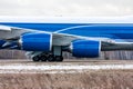 Close-up of cargo airplane engine, main landing gear and fuselage