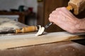 Close up of a Carpenter carving wood with chisel