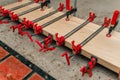 Close up of carpenter fastening board with clamps. Carpentry workshop. Side view Royalty Free Stock Photo