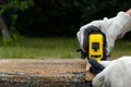 Close up of carpenter hand wearing working gloves and measuring plank with a tape measure Royalty Free Stock Photo