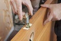 Close-up carpenter hands door lock installation. Royalty Free Stock Photo