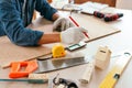 Close-up carpenter hands wearing work gloves draw the cutting line with a pencil on a wooden board. Construction industry, Royalty Free Stock Photo