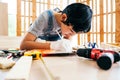 Close-up carpenter hands wearing work gloves draw the cutting line with a pencil on a wooden board. Construction industry, Royalty Free Stock Photo