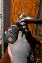 Close-up, the carpenter installs a custom lock in the front metal door, using a drill and hammer and other tools Royalty Free Stock Photo