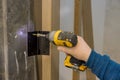 Close-up carpenter process of hands screwing hinge on a door with screwdriver Royalty Free Stock Photo