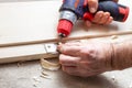 Close up of a carpenter screwed a hinge on a wooden plank Royalty Free Stock Photo