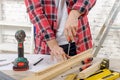 Close up of a carpenter screwed on a wooden plank