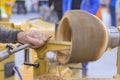 Close up: carpenter using chisel for shaping piece of wood on lathe