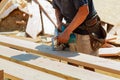 Close-up of carpenter using a circular saw to cut a large board of wood Royalty Free Stock Photo