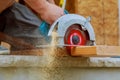 Close-up of a carpenter using a circular saw to cut a large board of wood Royalty Free Stock Photo