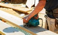 Close-up of a carpenter using a circular saw to cut a large board of wood Royalty Free Stock Photo