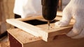 Carpenter using drill to screwing pieces of board at site Royalty Free Stock Photo