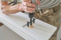 Close-up of carpenters hand using professional woodworking electric tools when working with wood. Male carving hole in wooden Royalty Free Stock Photo