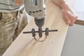 Close-up of carpenters hand using professional woodworking electric tools when working with wood. Male carving hole in wooden Royalty Free Stock Photo