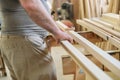 Close-up of carpenters hands with plank wood at carpentry woodworking workshop