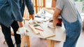 Close-up carpenters hands wearing work gloves draw the cutting line with a pencil on a wooden board. Construction industry, Royalty Free Stock Photo