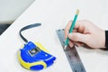 Close up Carpentry, mans hand using tape measure to measure wood plank and marking it with pencil. view from above Royalty Free Stock Photo