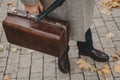 Close-up of carpetbag in hand of intelligent man