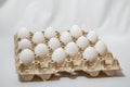 Close up of carton box with distanced white eggs on white background. concept of quarantine rules Royalty Free Stock Photo