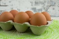 CLOSE UP OF CARTON OF SIX BROWN RANGE HEN EGGS ON URBAN BACKGROUND AND GREEN MAT Royalty Free Stock Photo