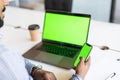 Close up of casual man or freelancer working on laptop computer and holding mobile smart phone with reflection on blank screen, Royalty Free Stock Photo