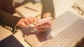 Close up of casual woman or freelancer working on laptop computer and holding mobile smartphone, working from home or casual Royalty Free Stock Photo